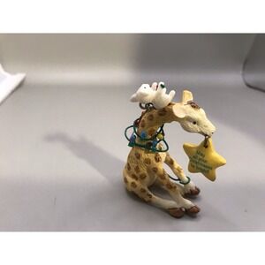 Tiny Giraffe Entwined In Christmas Lights With Kitten On It's Head